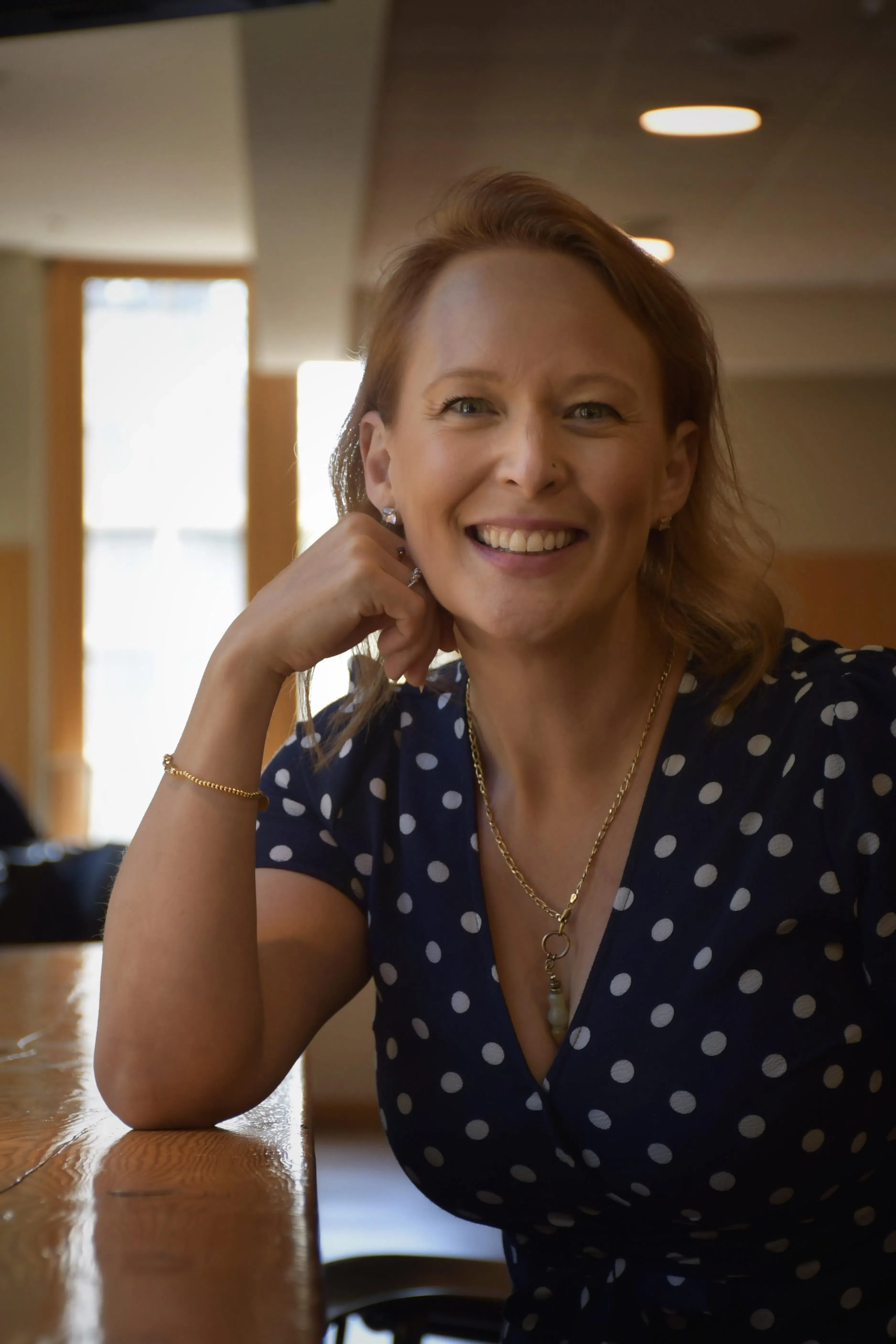Shelley Doyle smiling at a desk in a bright workspace